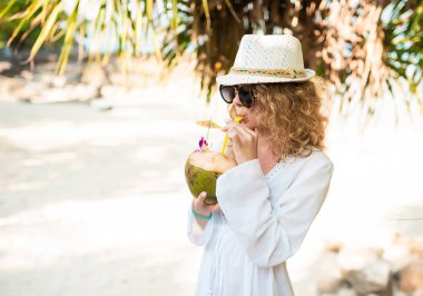 Sahilde kokteyl Hindistan cevizi ile zarif kıvırcık kadın