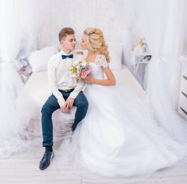 Düğün stüdyosu çekimleri, dekor öpücükler, sarılmalar. Mutlu bir çift. Lüks dekorasyonlu gelin ve damat aşıkları. Gelin ve damat birlikte. Çift kucaklaşması. Yeni evliler evleniyor.