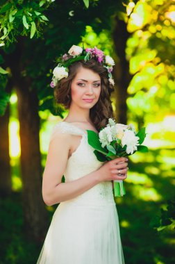 Güzel gelin esmer beyaz gelinlik parlak makyaj ve saç modeli ile poz portresi. güzel gelin düğün buket holding