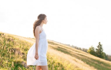 Chamomiles dağın tepesine görünümünde bir sıcak yaz gününde zevk bir sürü kıvırcık genç kadın. genç güzel kadın portre. Yaşam tarzı kavramı