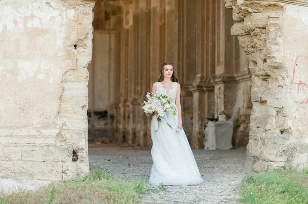 Romantische mooie bruid in luxe jurk poseren van prachtige architectuur — Stockfoto