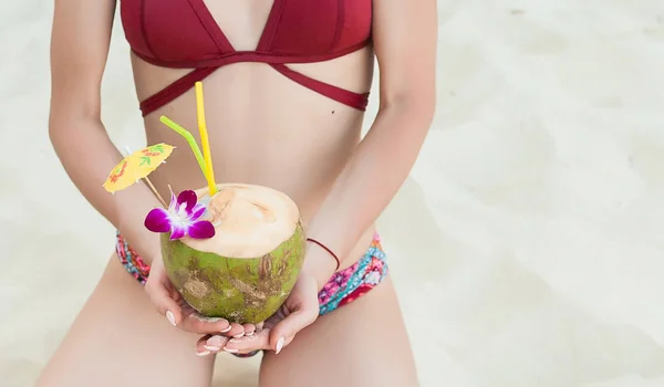 Mulher encaracolada elegante com coquetel de coco na praia — Fotografia de Stock