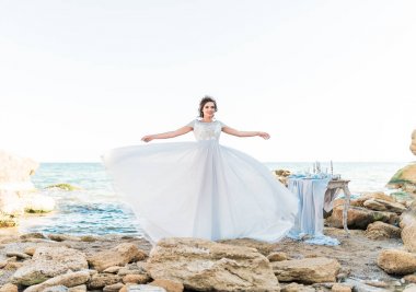 Sahilde poz lüks elbiseli romantik güzel gelin.