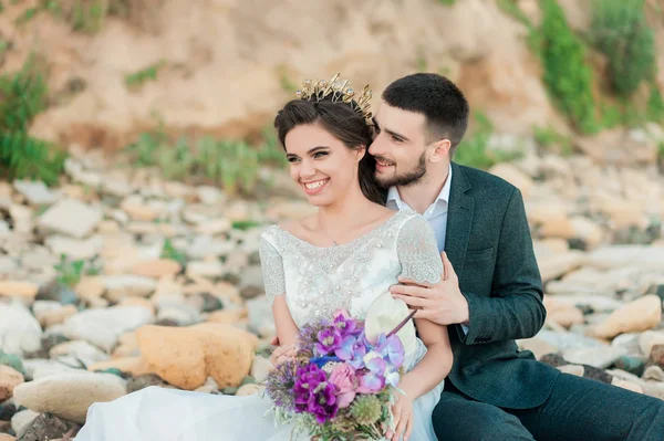 Noiva e noivo em vestido de noiva à beira-mar — Fotografia de Stock