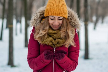 Model, şık örgü kış şapkası ve eldivenleriyle gözlerini kapadı..