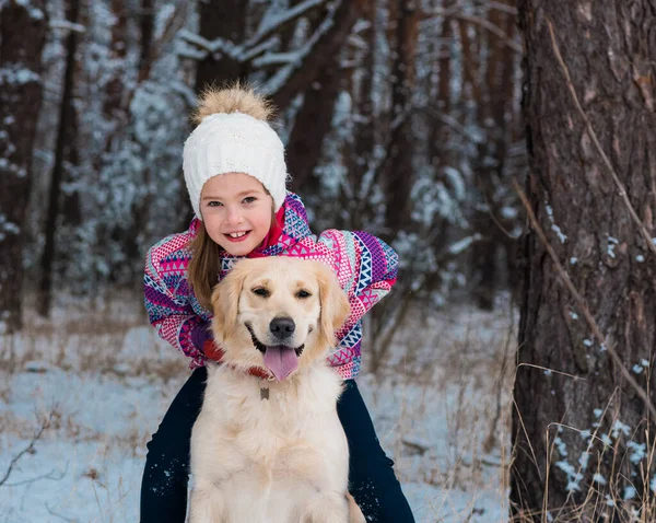 Cheerful girl hugging with smile dog golden retriever in snow outdoors — Stock Photo, Image