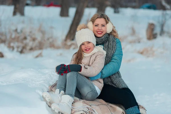 Familjen sitter på en bänk vid en frusen sjö. — Stockfoto