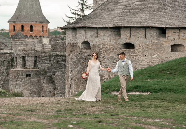 Жених и невеста на свадебной церемонии у старого замка — стоковое фото