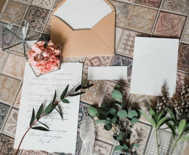 Arka planda süslemeleri olan düğün davetiyesi