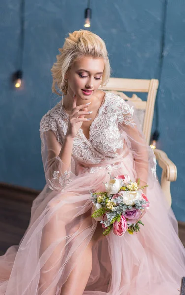 美しい花嫁でウェディングドレスポージングで花束で手 — ストック写真