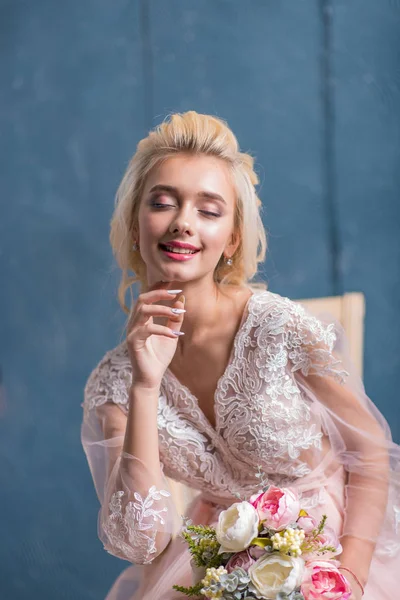 Brud i en bröllopsklänning i studion med vit inredning — Stockfoto