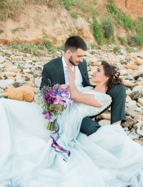 Mutlu evli çift düğün günü deniz kenarında kumsalda.