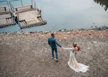 Gelin ve damat göl arka planında düğün töreninde..