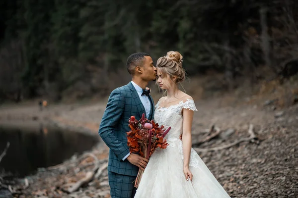 Gelin ve damat göl arka planında düğün töreninde..