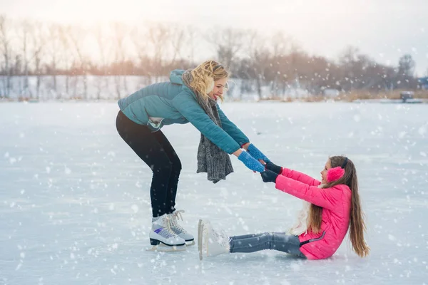 Familia joven divertirse en la zona de hielo en un parque cubierto de nieve —  Fotos de Stock