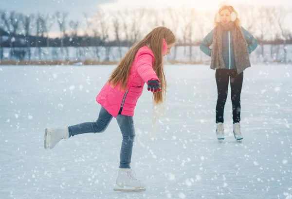 Mladá rodina užívající si den v ledové oblasti v zasněženém parku — Stock fotografie
