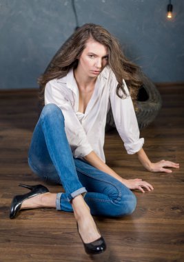 Mavi kotlu gri arka planda poz veren model.