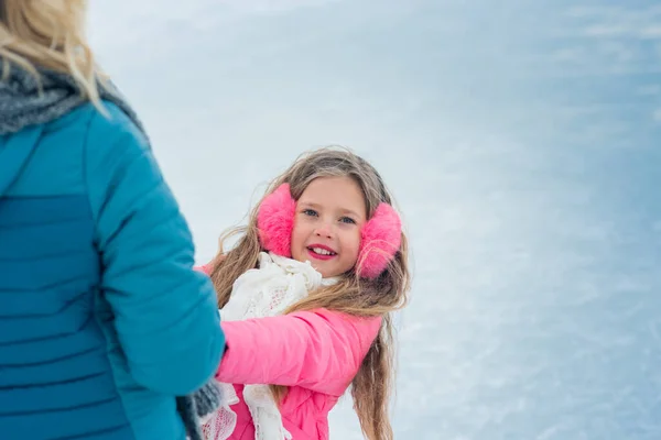 La chica en patinaje sobre hielo en ropa rosa mirando a mamá — Foto de Stock