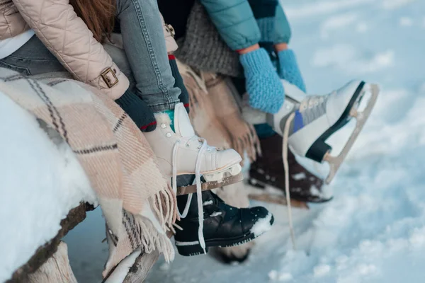 Familia se sienta en un banco en la orilla de un lago congelado . — Foto de Stock