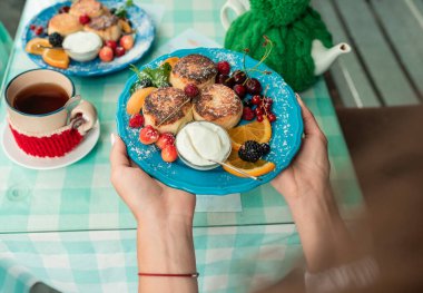 Cam masada meyvelerle süslenmiş peynirli kekler.