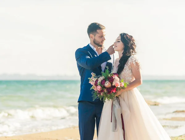 Casamento casal, noivo e noiva em vestido de noiva perto do mar à beira-mar — Fotografia de Stock