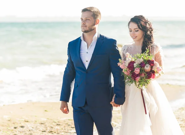 Casamento casal, noivo e noiva em vestido de noiva perto do mar à beira-mar — Fotografia de Stock