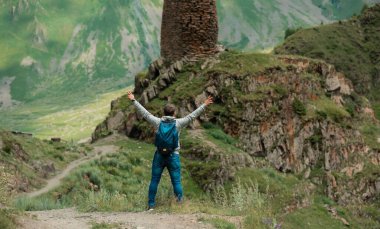 Man Traveler 'ı yaklaş, dağ nehri manzaralı bir uçurumda oturuyor. Dağların başarısı ve eğlence coşkusu. Yaşam tarzı insanlar dışarıda, yaz vahşi doğa