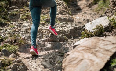 Atletik bacaklı bir kadın koşuya çıkıyor ya da gün doğumunda ya da gün batımında koşuyor. Sağlıklı yaşam tarzı kavramı