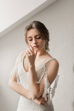 Pencerenin yanında uzun bir elbise ile sevimli gelin. Damadı bekliyorum. Düğün iç. Otelde güzellik moda gelin. Güzel bir gelinin portresi. Düğün fotoğrafçılığı.