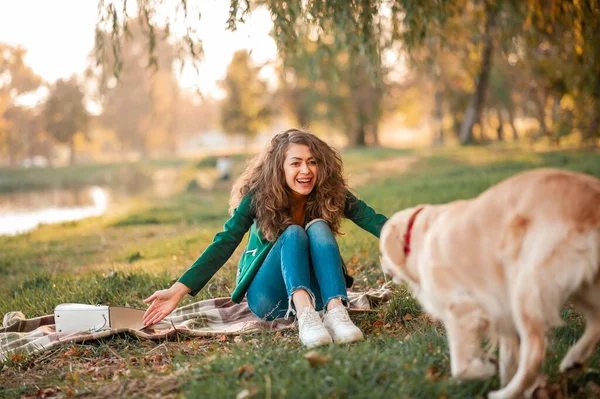 快乐的女人和金发碧眼的猎犬一起在外面的公园里年轻的女主人在公园里抱着宠物 用褐色毛毯垫着 爱和爱护宠物 — 图库照片