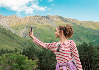 Kız dağın tepesinde mükemmel manzaralı bir bağlantı arıyor..