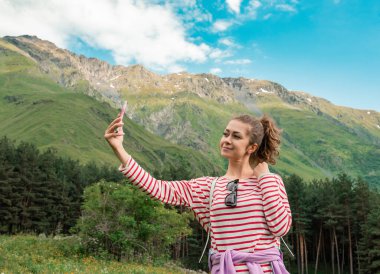 Kız dağın tepesinde mükemmel manzaralı selfie çekiyor..