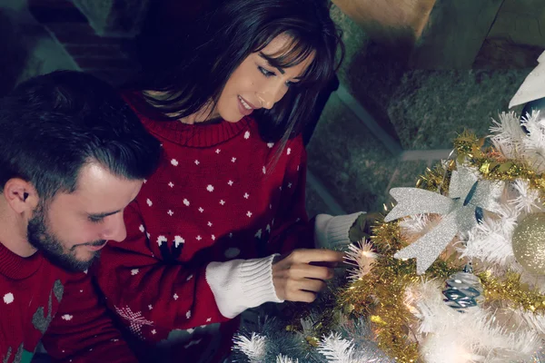 Casal jovem decorando uma árvore de Natal — Fotografia de Stock