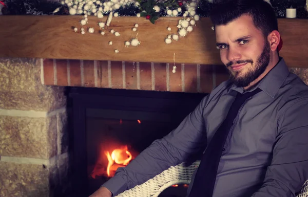 Man sitting next to the fireplace — Stock Photo, Image