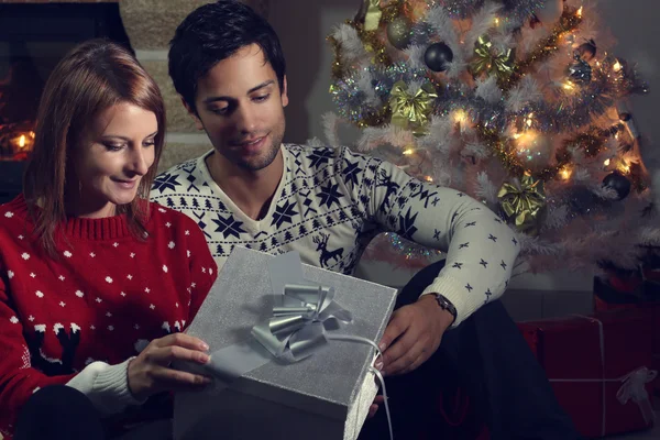 Jeune couple ouvrant un cadeau de Noël — Photo