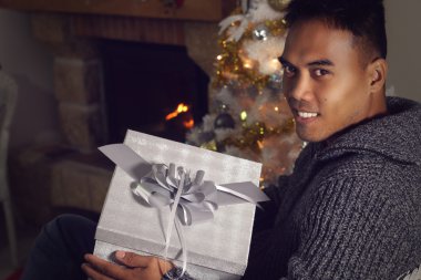 Genç bir Noel hediyesi tutan Filipino