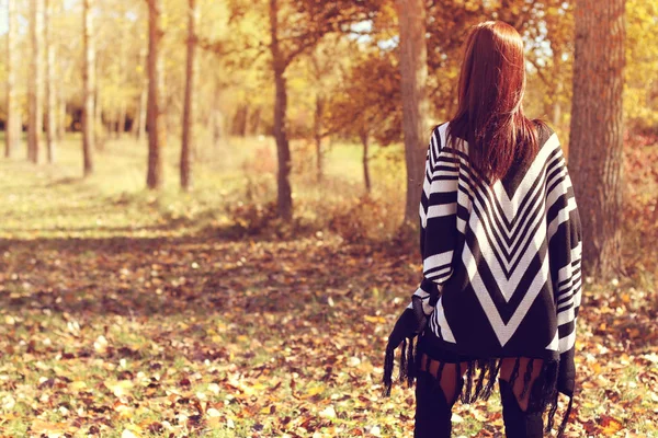 Tânăra femeie se uită în pădure toamna — Fotografie, imagine de stoc
