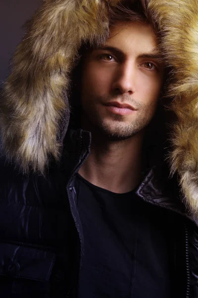 Winter mode. Knappe man dragen bont capuchon — Stockfoto