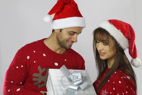 Ung man erbjuder en julklapp för hans flickvän — Stockfoto
