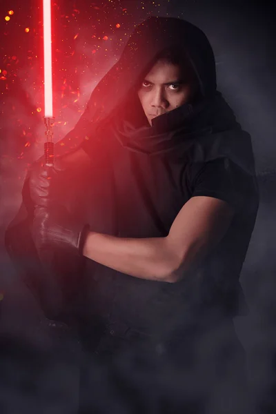 Karanlık savaşçı bir kırmızı ışık kılıç holding — Stok fotoğraf