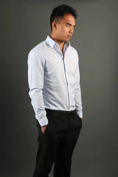 Elegantní muž na sobě modrou košili a černé kalhoty, které představují — Stock fotografie