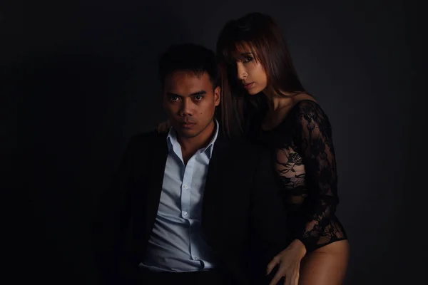 Donna sexy che indossa lingerie posa accanto a un uomo elegante — Foto Stock