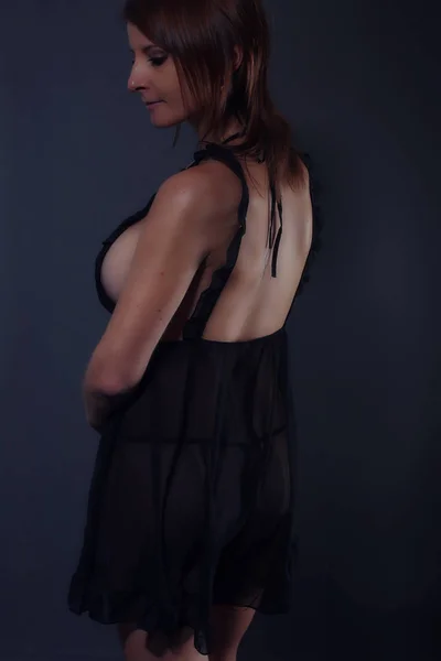 Vollbusige Frau trägt ein schwarzes Nachthemd — Stockfoto