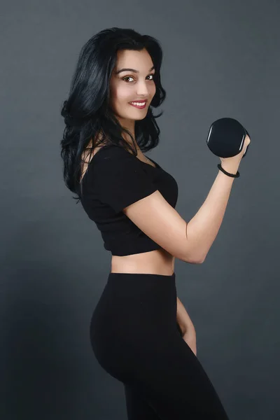 Young woman holding a dumbbell — Stock Photo, Image