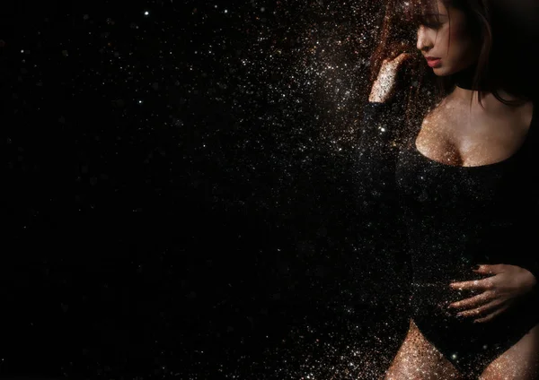 Beautiful woman creating a glitter dispersion effect — Stock Photo, Image