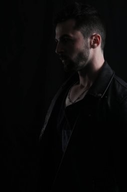 Bir deri ceket giyen bir adamın dramatik resmi