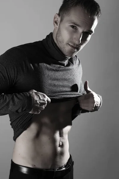 Retrato de homem musculoso posando em estúdio e mostrando seus abdominais — Fotografia de Stock