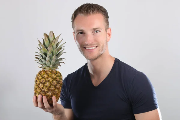 Mannen med ananas poserar — Stockfoto