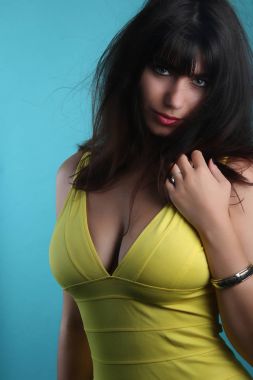 Sarı bir elbise giyen güzel busty genç kadın