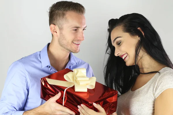 Alegre feliz casal oferecendo um presente — Fotografia de Stock